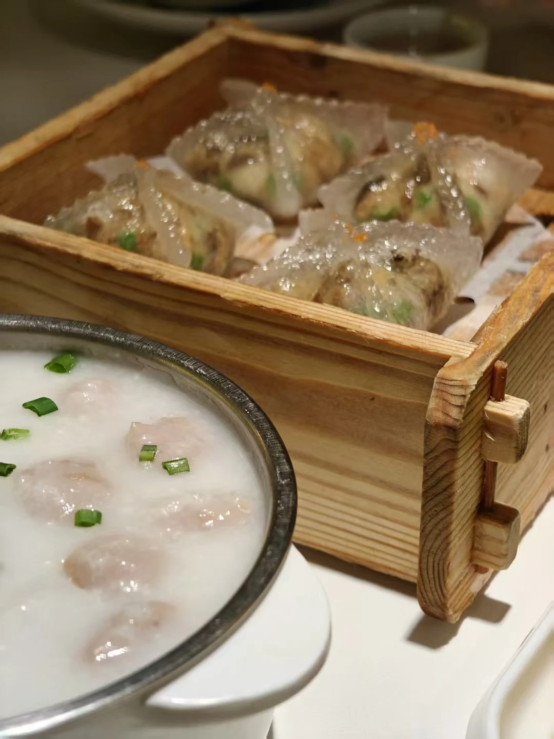 Steamed dumplings and congee in a bamboo steamer, an easy local first meal in China